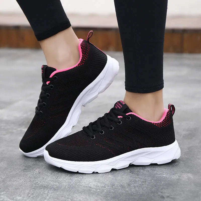 Women's sports running shoes in white with mesh and Flyknit upper, flat heel, and lace-up front