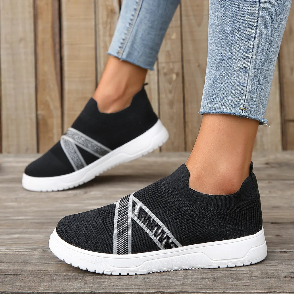 Women's black flyknit mesh outdoor shoes with flat rubber sole and tassel detail.