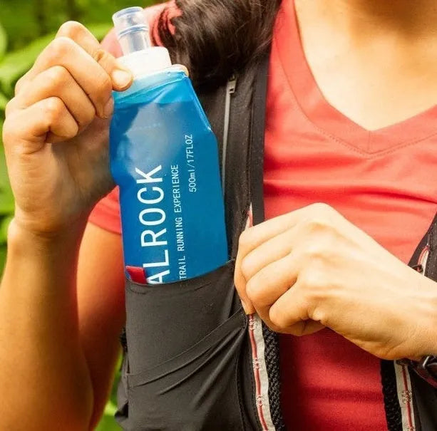 Grey portable water filter straw with textured grip and long flexible silicone tube, shown with a carabiner clip.