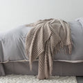 Small grey polyester lap blanket folded, showing its 127 by 170 cm size.