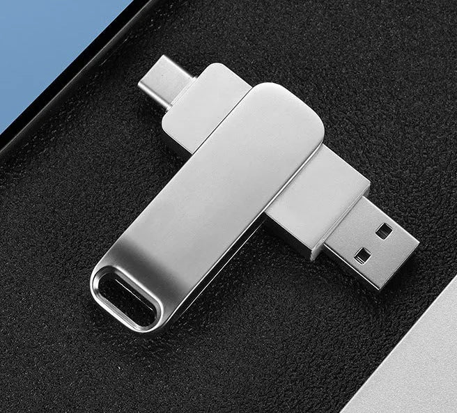 Rotating metal USB flash drive showing USB and USB-C connectors with black finish and protective iron box packaging
