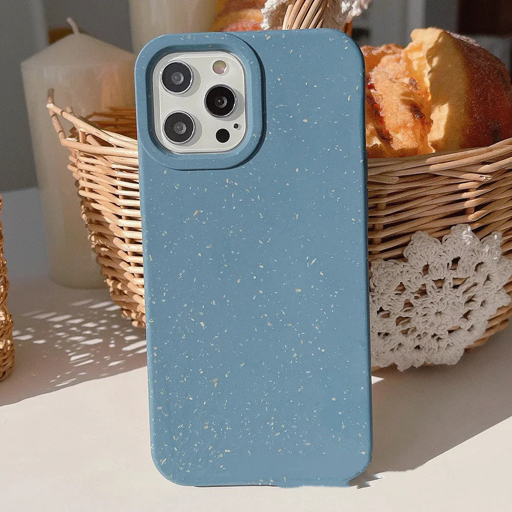 A degradable wheat straw phone case for iPhone on a wooden surface, showing its rear cover design.