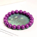 Jiuya brand purple mica crystal bracelet with polished beads on a wrist.