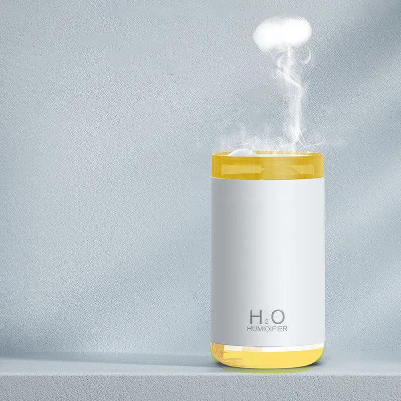 Blue jellyfish USB humidifier with night light on wooden table, showing mist output