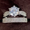 A white gold-coloured geometric bracelet ring with an integrated round element on a model's finger.