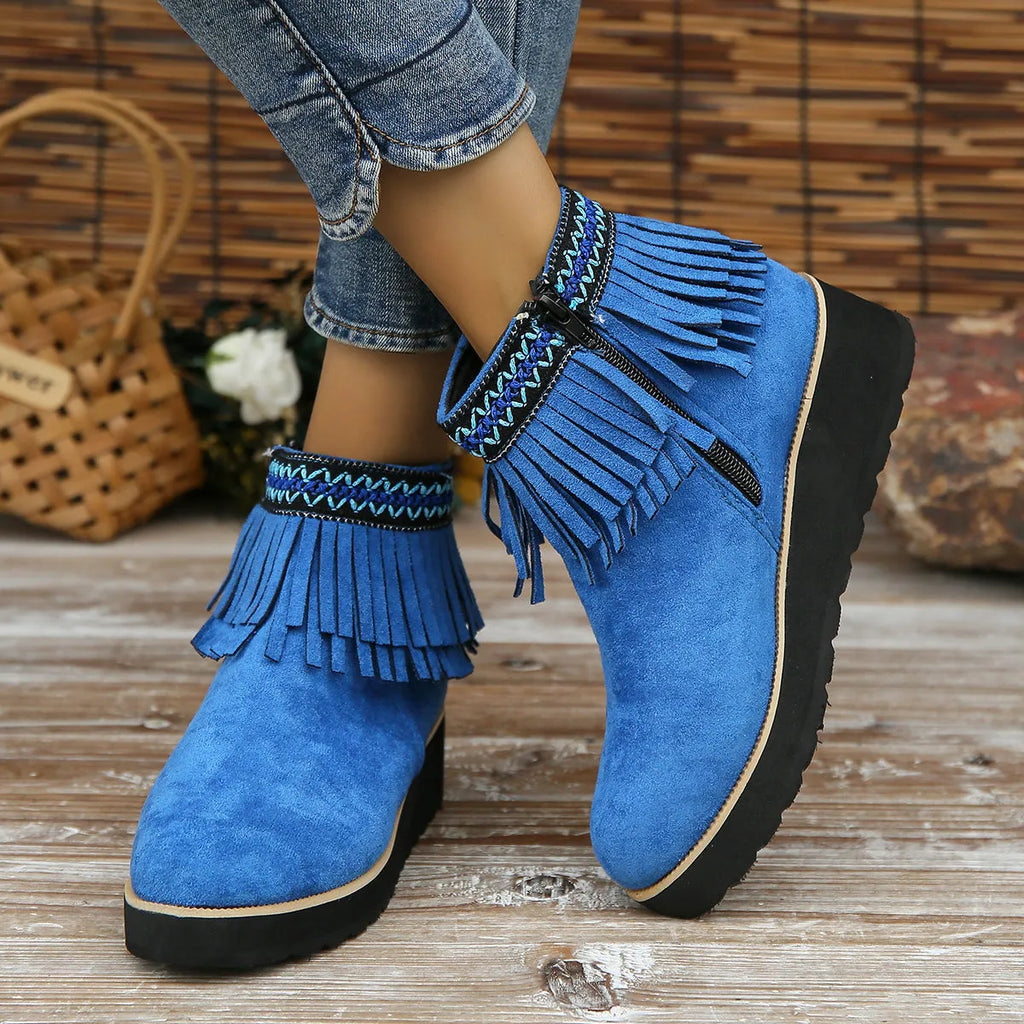 Women's black suede wedge bootie with a thick sole, side zipper, and tassel detail.