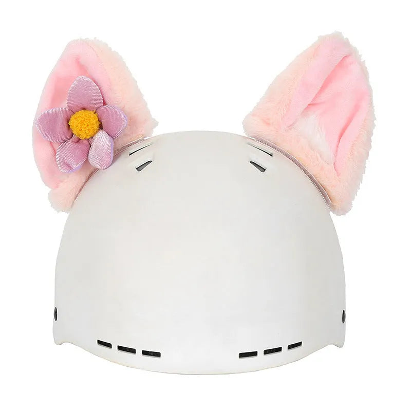 Soft plush helmet cap with cartoon character design, shown on a wireless earbud charging case.
