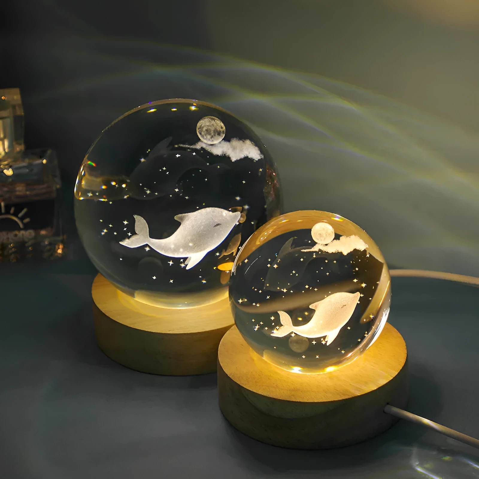 Transparent crystal ball night lamp with 3D carved jellyfish design, lit with soft blue glow on a round base.