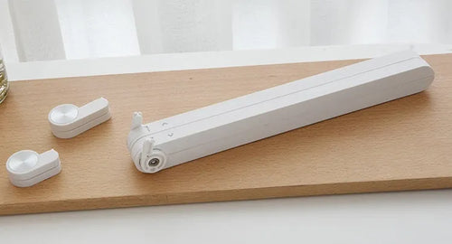 White folding bracket cushion supporting an Apple laptop on a desk.
