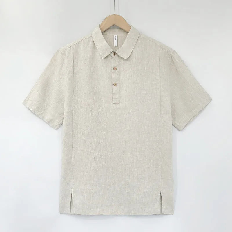 Man wearing a loose-fit light grey linen V-neck short-sleeve top on a summer day.
