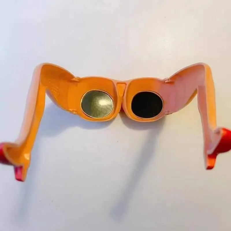 Orange novelty sunglasses with a unique leg-hip frame design, shown from the front. Oversized 15cm by 20cm dimensions.