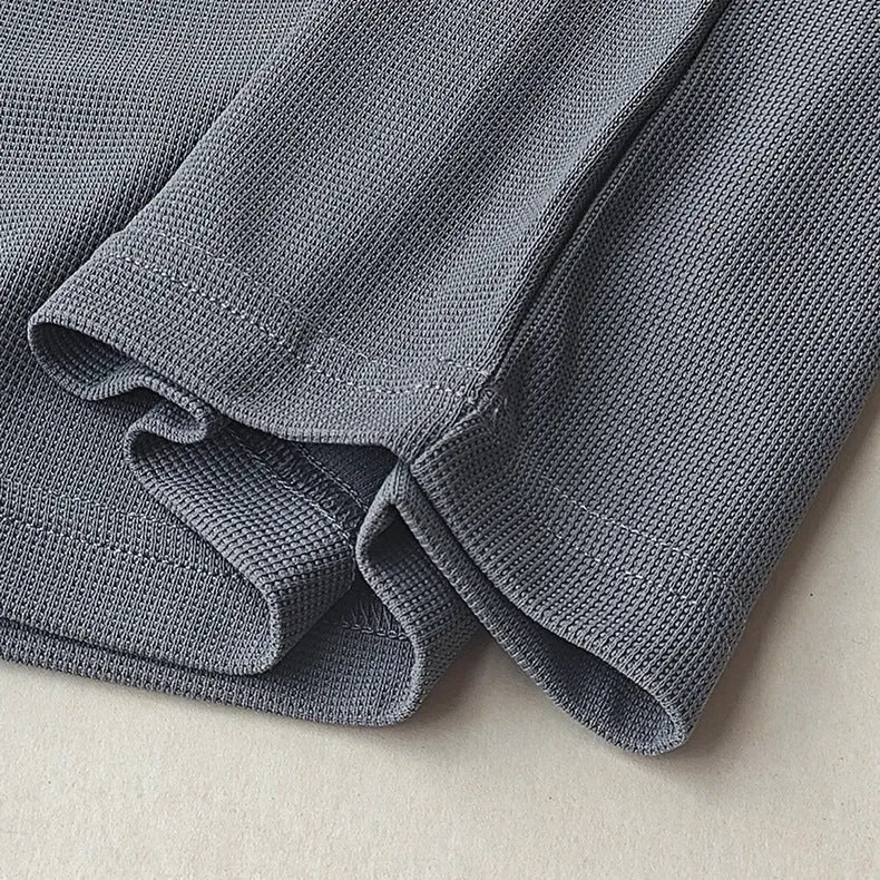 Men's heavyweight waffle-knit short-sleeve t-shirt in a solid colour on a size chart background.