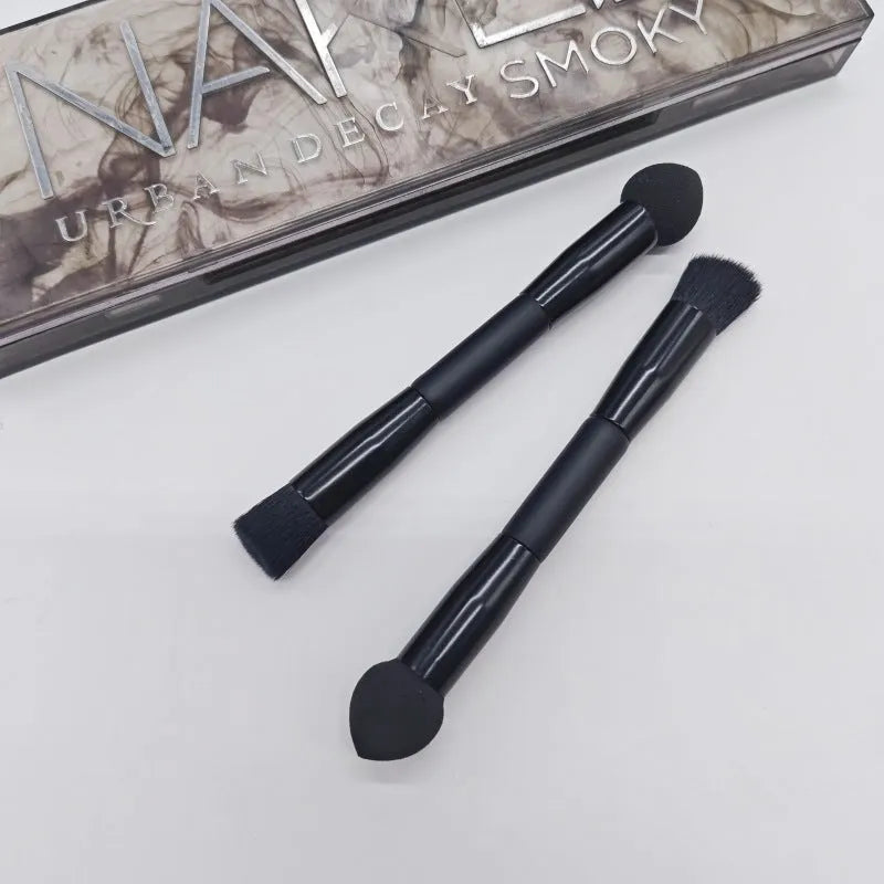 Black double-headed concealer brush with sponge end and tapered brush end on wooden handle