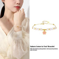 Pink women's bracelet with silver chain, Hetian jade beads, and a detailed cherry blossom flower pendant.