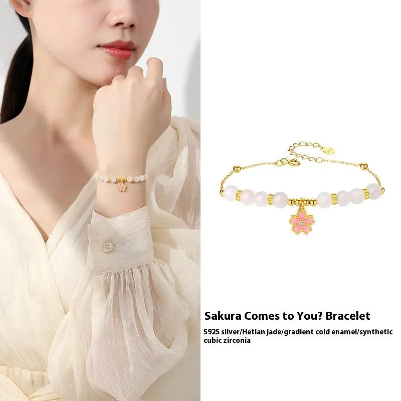 Pink women's bracelet with silver chain, Hetian jade beads, and a detailed cherry blossom flower pendant.