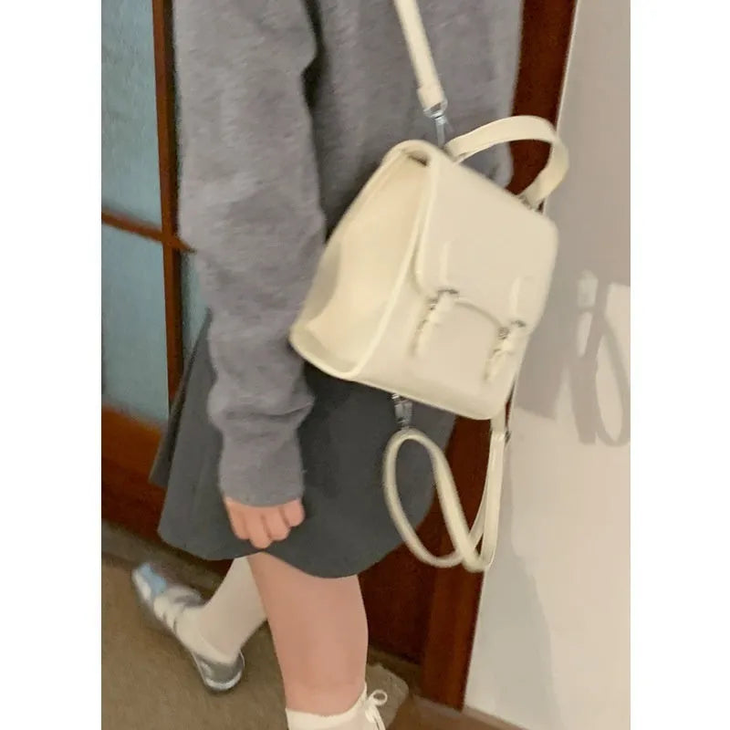 Simple PU backpack in urban college style, available in white, black, wine red, and silver, with polyester lining and sewing thread detail.