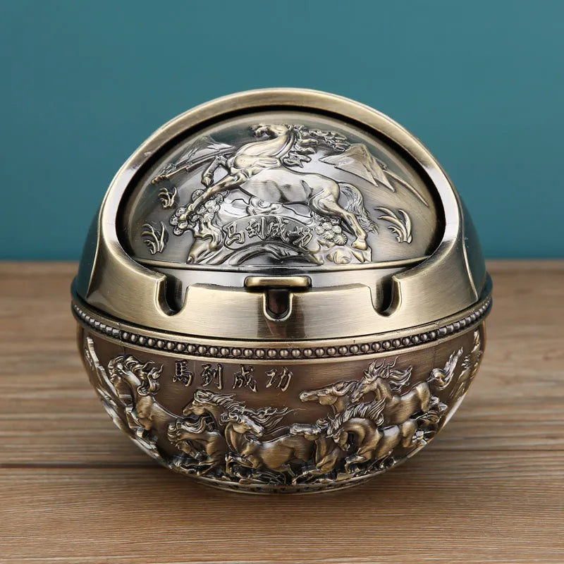 Alloy decorative ashtray in bronze with ornate peacock motif and cigarette extinguishing slot.