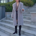 A grey women's mid-length faux fur coat with a fur collar and regular sleeves on a hanger.