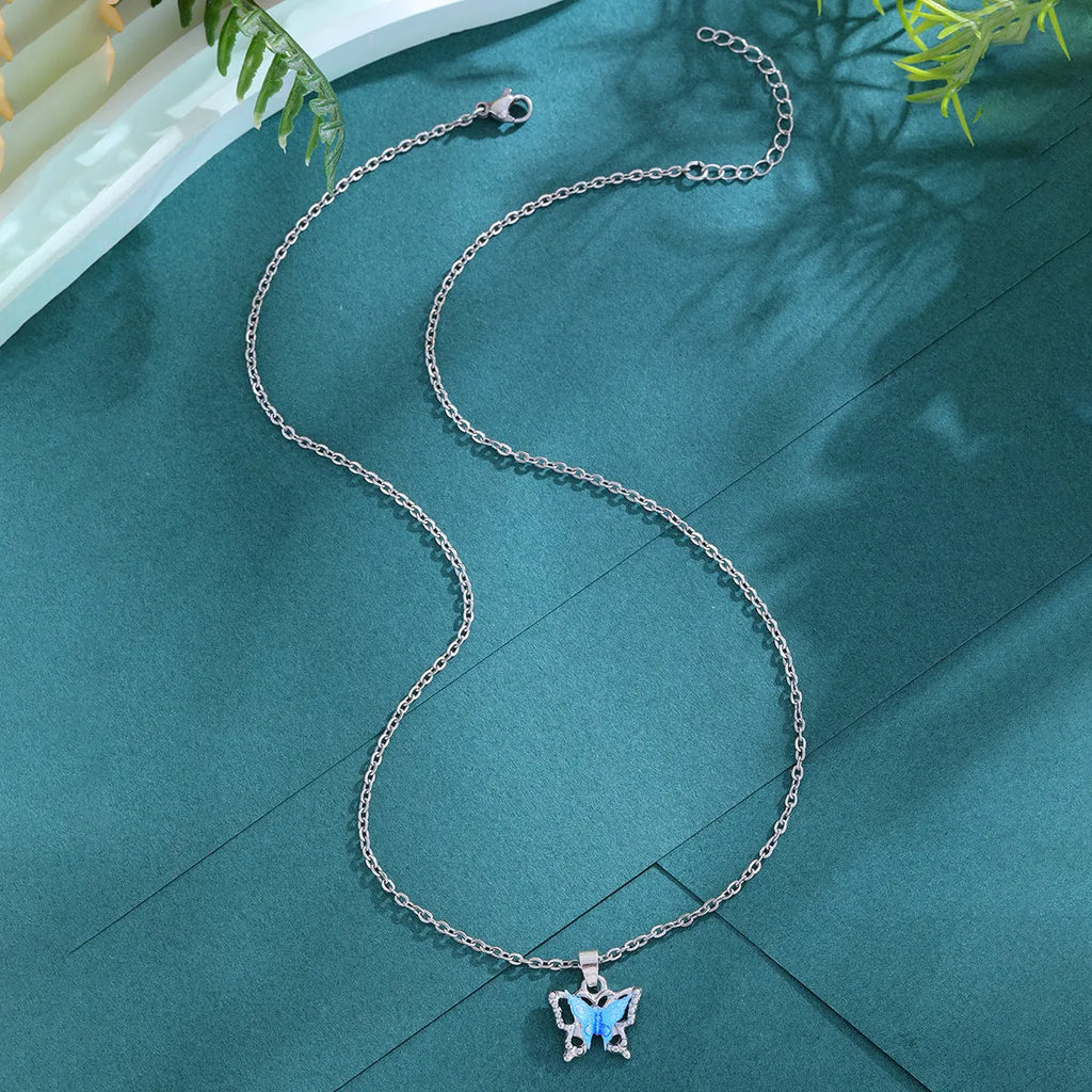 Blue three-dimensional butterfly pendant necklace for women on a light background