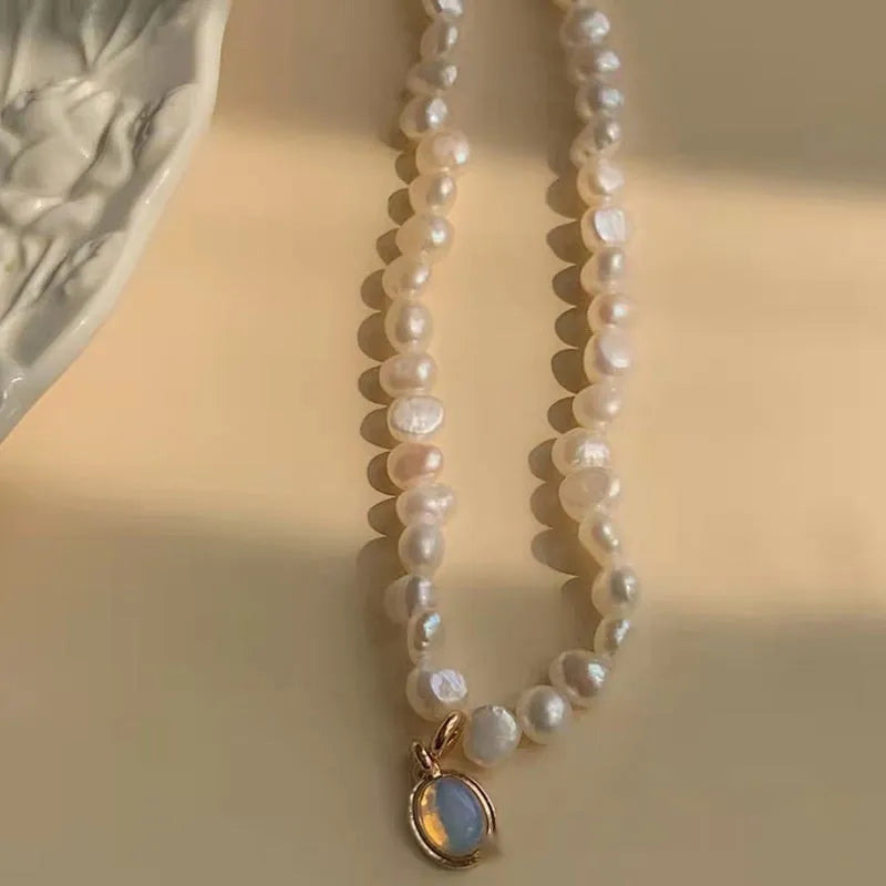 Vintage geometric pearl necklace with adjustable chain on a dark background.