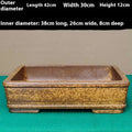 Straight-sided shallow rectangular Yixing flowerpot made from unglazed purple clay on a wooden surface.