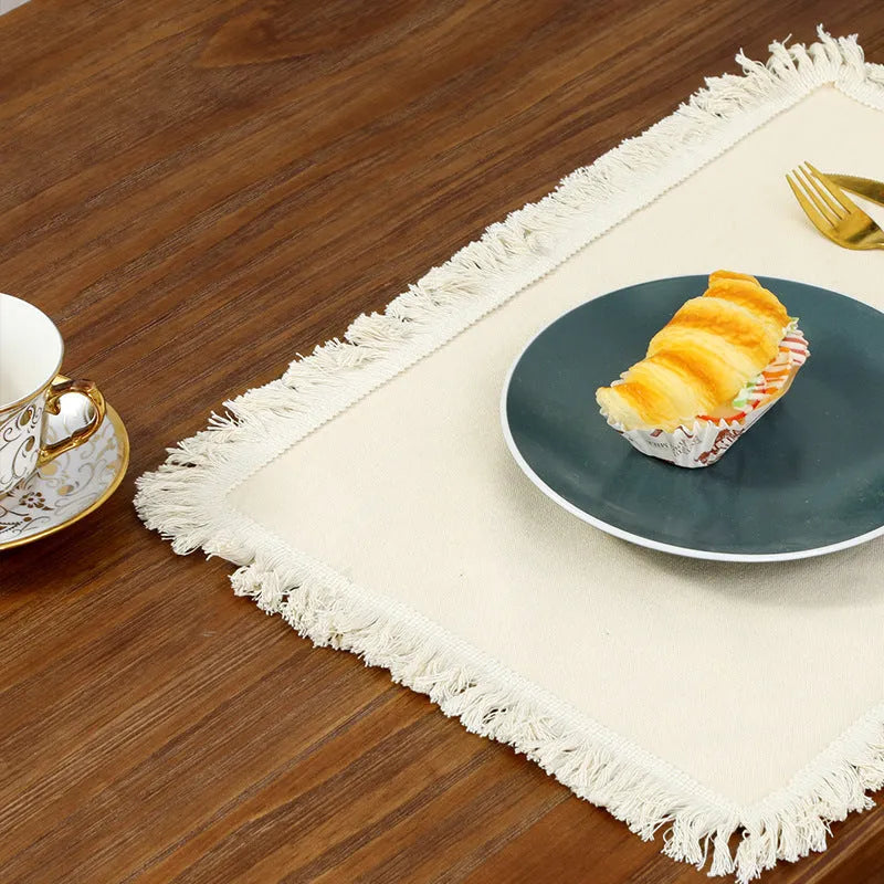 Solid colour square polyester placemat on table in beige colour