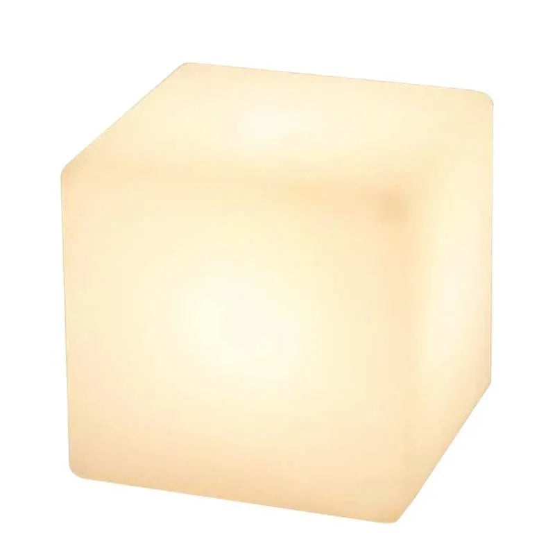 A modern square white LED cube light functioning as a waterproof stool for outdoor gardens.