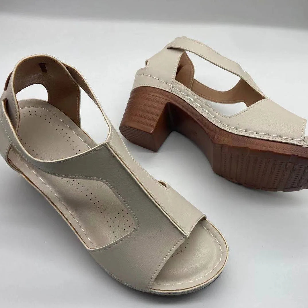 Women's beige peep toe wedge sandals with a buckle strap, shown on a foot.