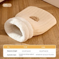 Fleece cat sleeping bag nest in light brown colour with a 3D entrance, shown on a wooden floor.