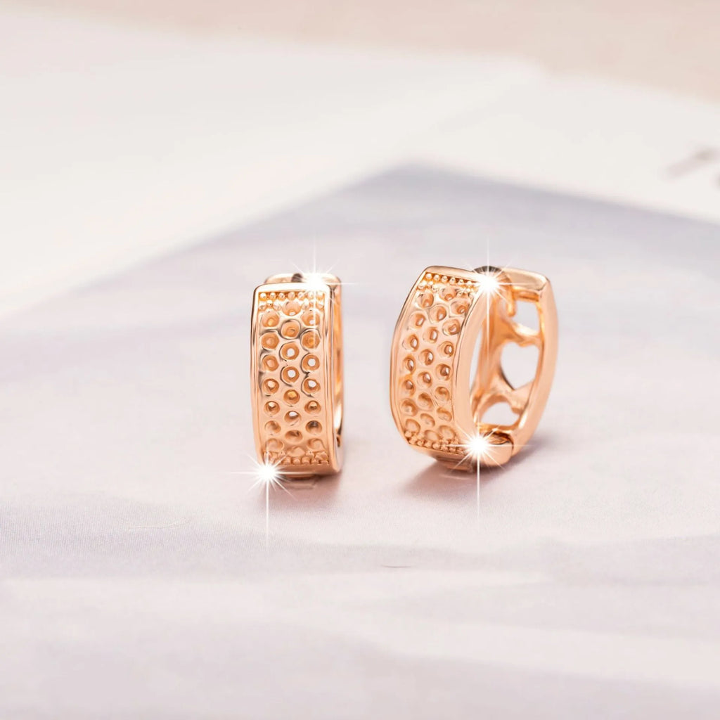 Pair of rose gold women's earrings with a 1.5cm hollow heart shape and three smaller heart cut-outs.
