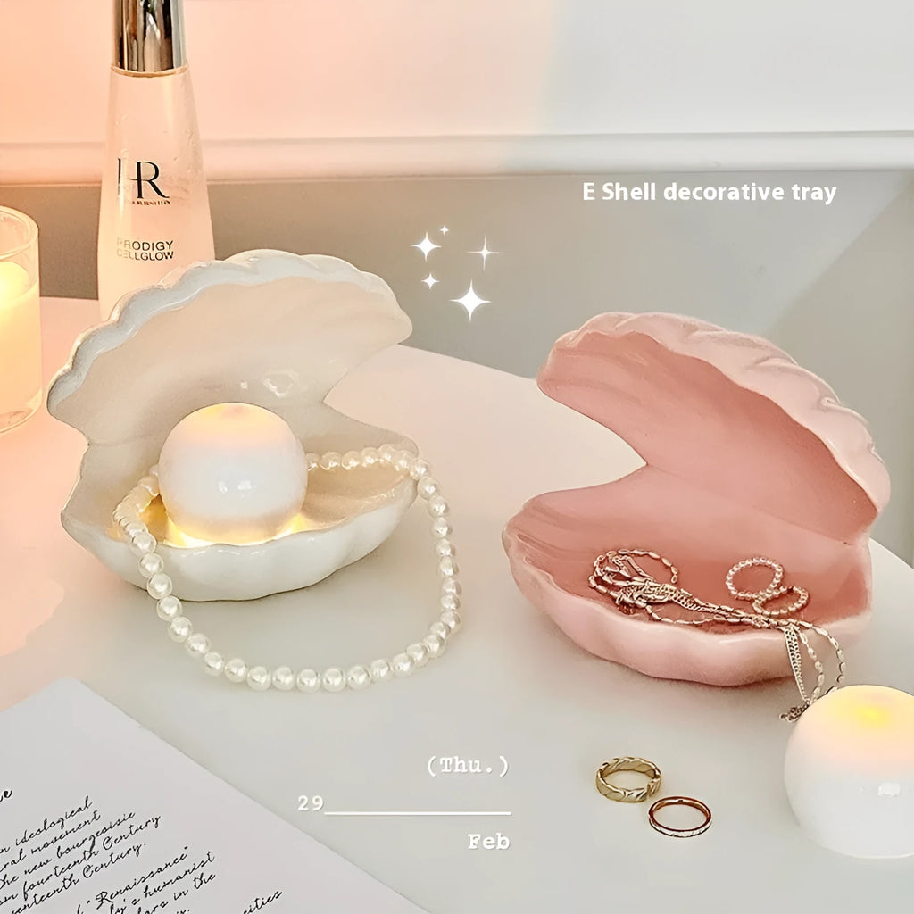 Yellow and white porcelain shell-shaped tray with integrated small LED night light on a wooden surface.