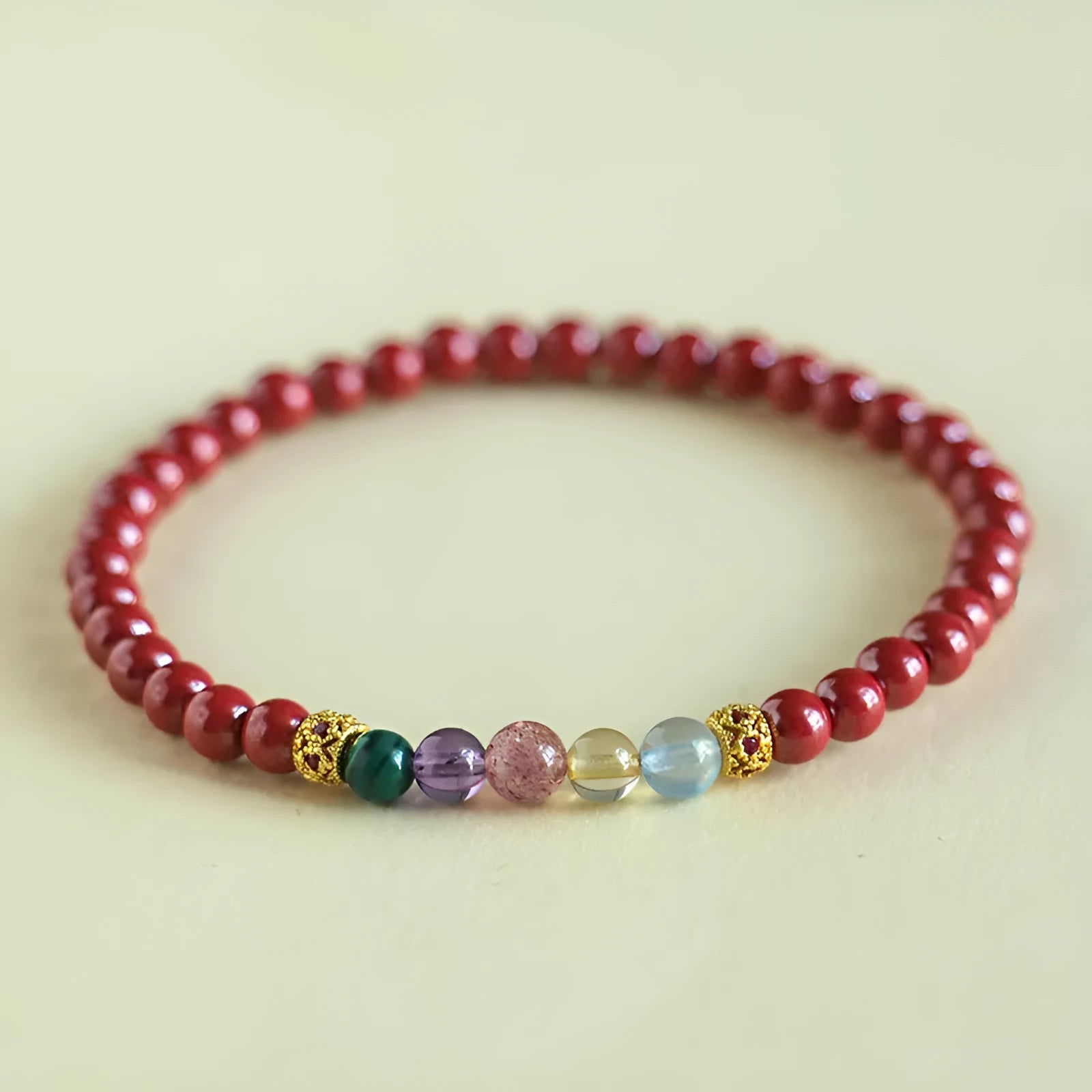 Purple gold cinnabar crystal bead bracelet on wrist showing handcrafted string construction