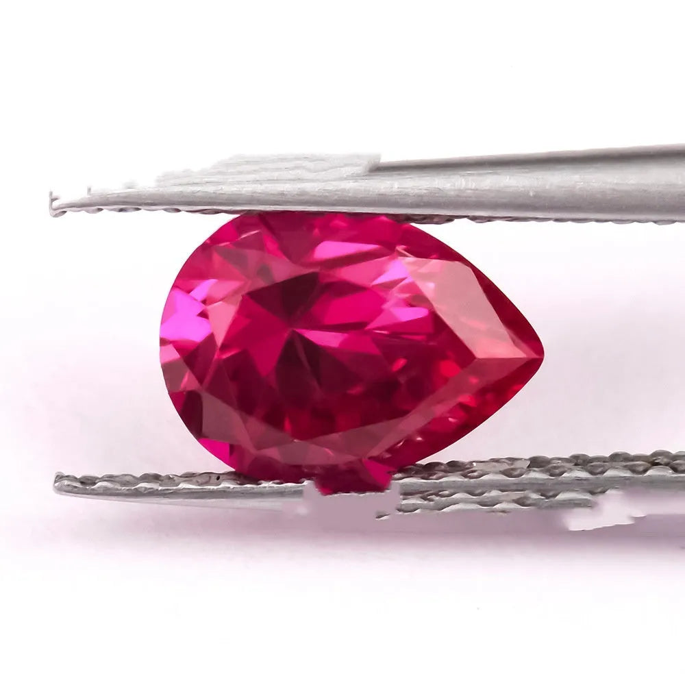 Cultivated ruby gemstone in pigeon blood red colour showing various cut styles including round, egg shape, and water drop