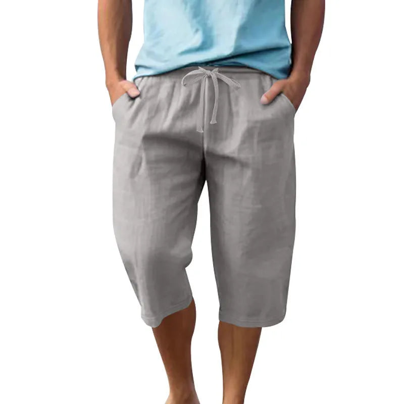 Man wearing light blue linen casual shorts with a cropped length and high waist.