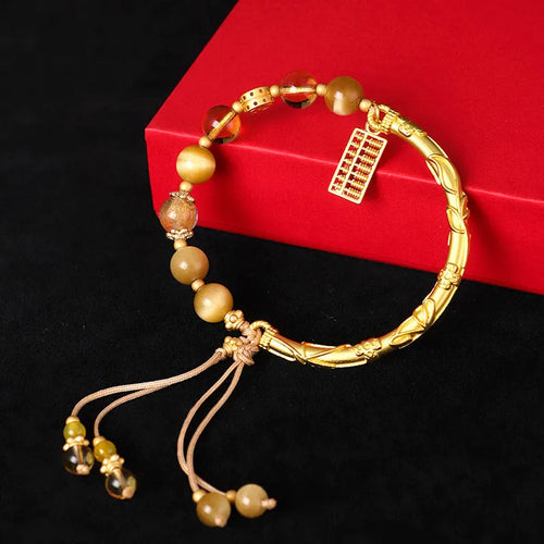 Handmade beaded bracelet featuring tigereye and citrine stones with yellow tower crystal and diamond-shaped copper parts