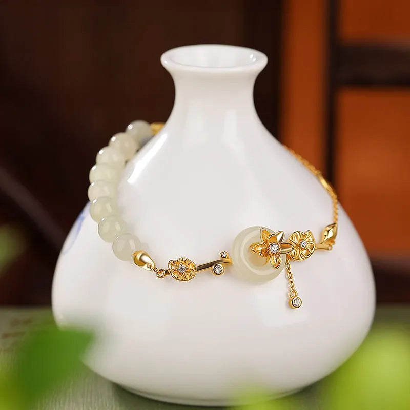 Antique style women's bracelet with peace buckle, inlaid Hetian jade lotus, on a silver chain.