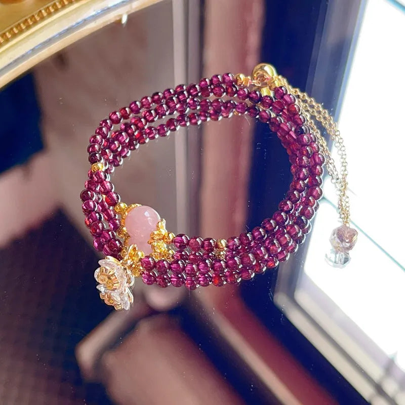 Close-up of a women's double ring bracelet made with natural garnet stones in H311 colour.