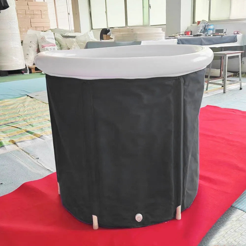 Black inflatable portable ice bath tub with elasticated cover, shown with air pump and drainage accessories
