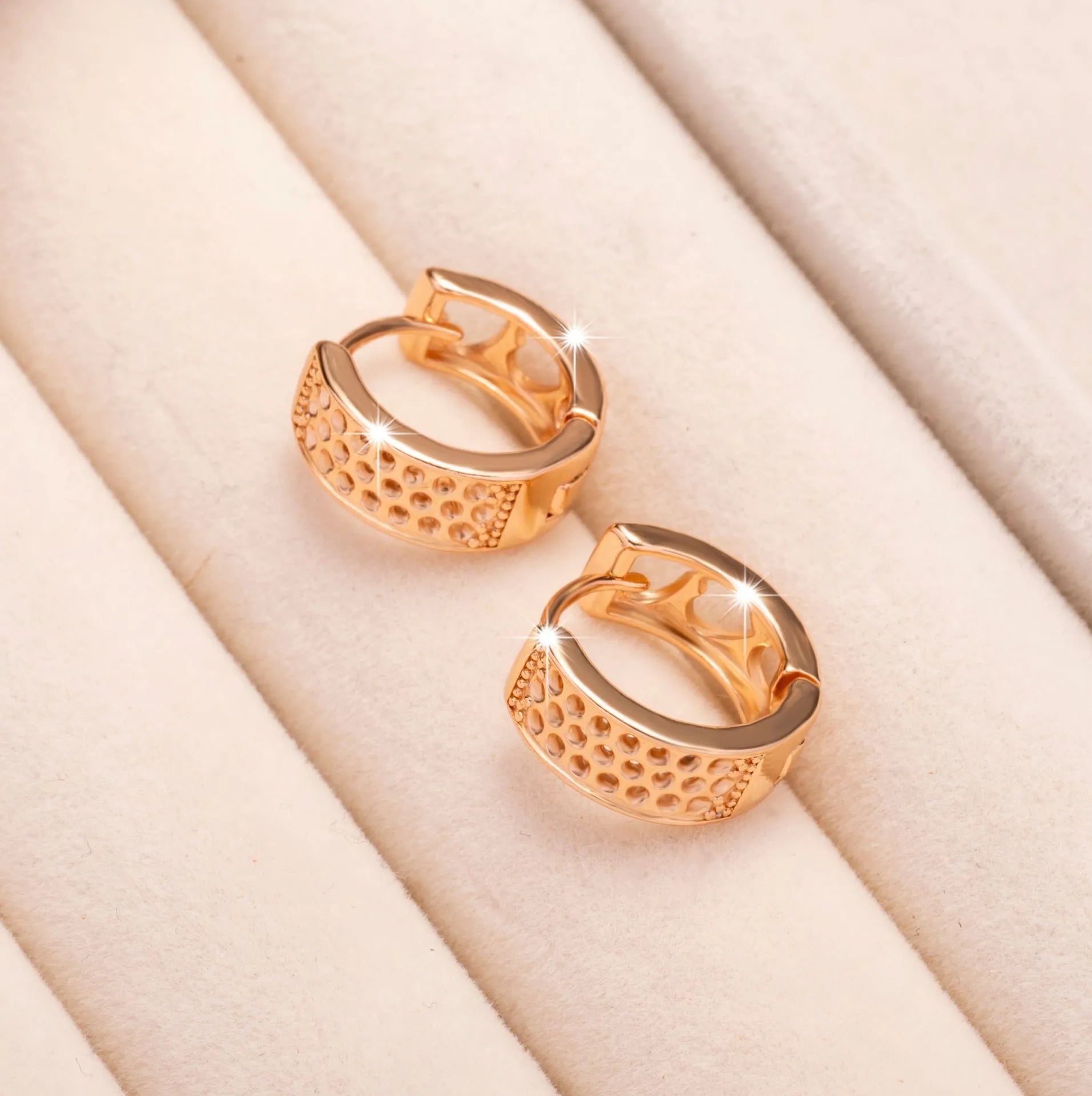 Pair of rose gold women's earrings with a 1.5cm hollow heart shape and three smaller heart cut-outs.