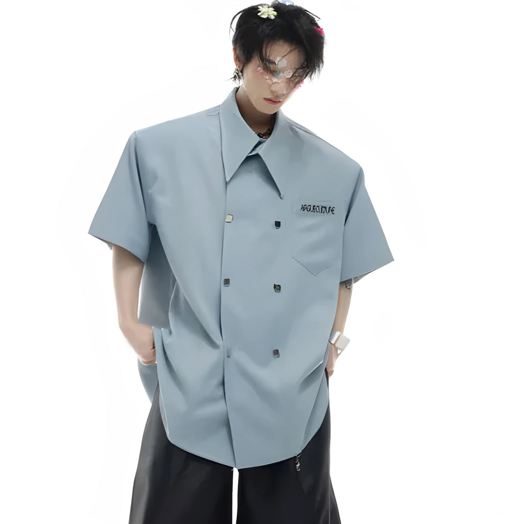A man's loose-fitting casual short-sleeved shirt in blue with metal buttons and contrast panel detail.