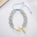 Close-up of a women's woven bracelet with a butterfly motif and a central aquamarine gemstone bead.