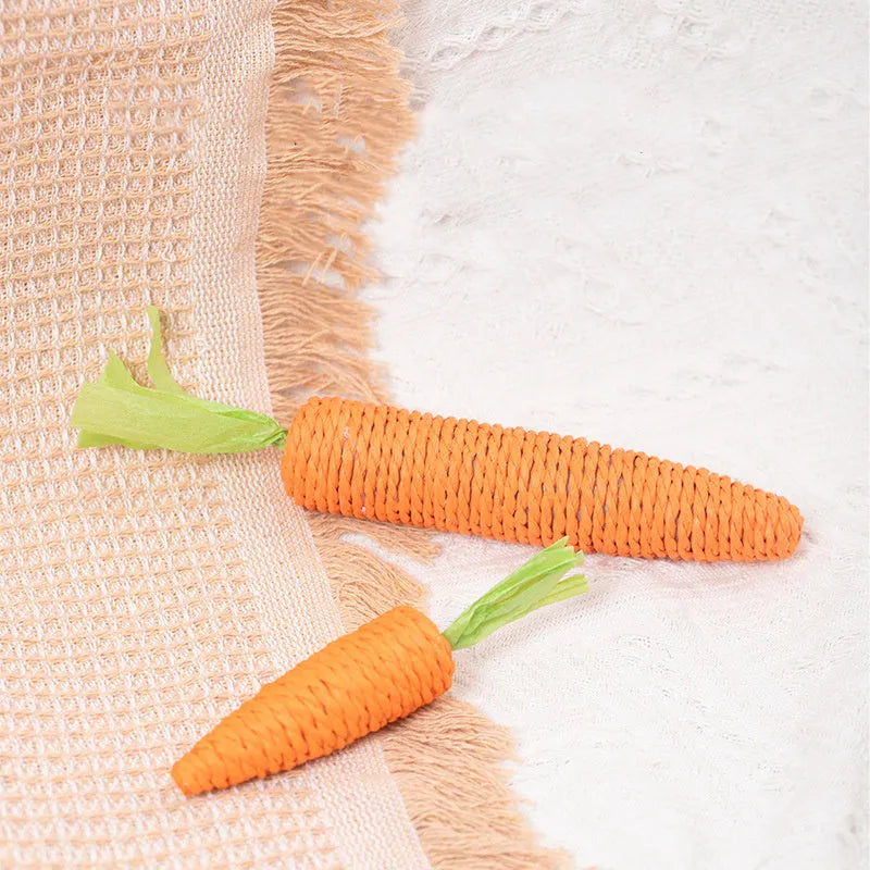 Cat toy set with carrot-shaped paper bites, ringing stones, and grinding sticks on soft surface