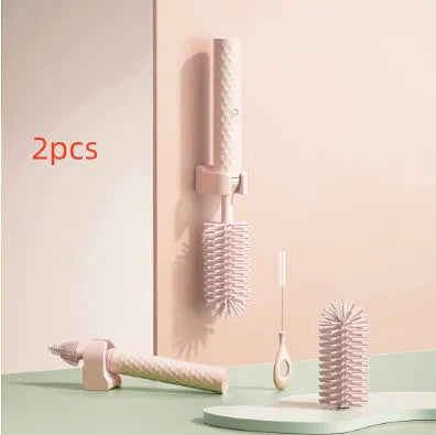 Pink and green electric baby bottle brush with rotating silicone head and USB charging cable