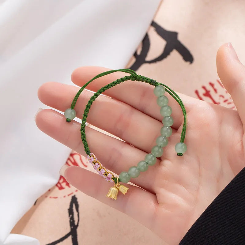 Red rope hand woven women's bracelet with floral elements in national style