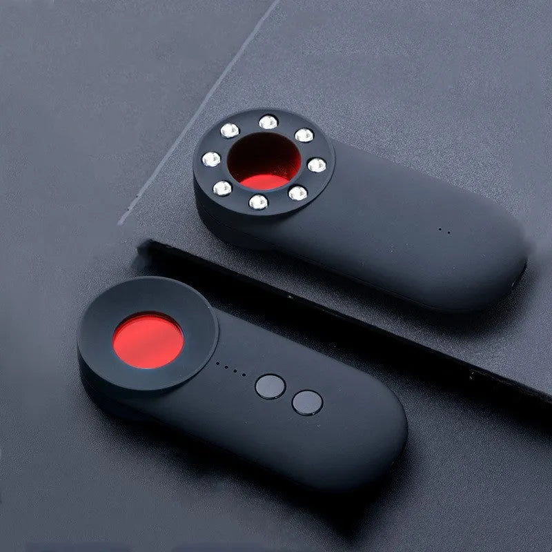 Black portable GPS and hidden camera detector with USB cable on a flat surface.