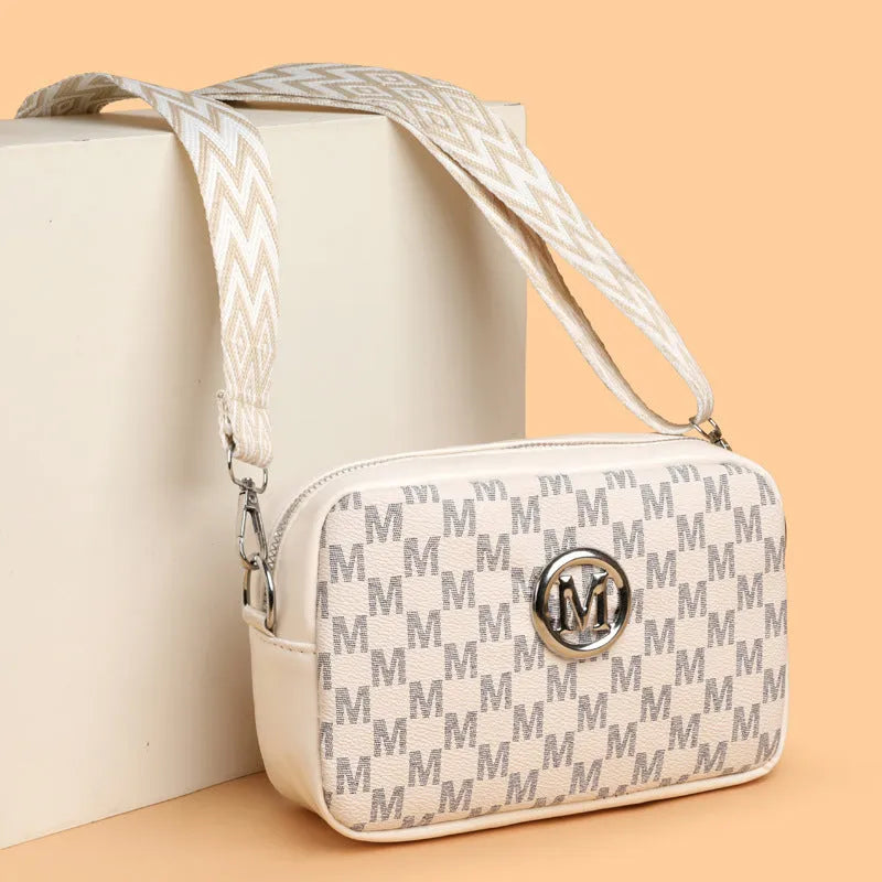 Crossbody bag with wide shoulder strap showing three-dimensional front pocket organisation