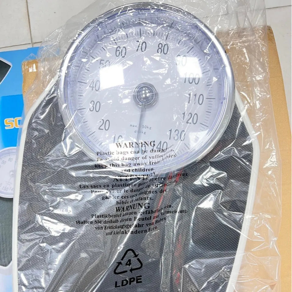Black mechanical pointer bathroom scale on floor showing large dial and 47x35cm platform.
