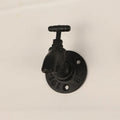 Metal water pipe style wall hanging hook in a choice of colours on a white wall.
