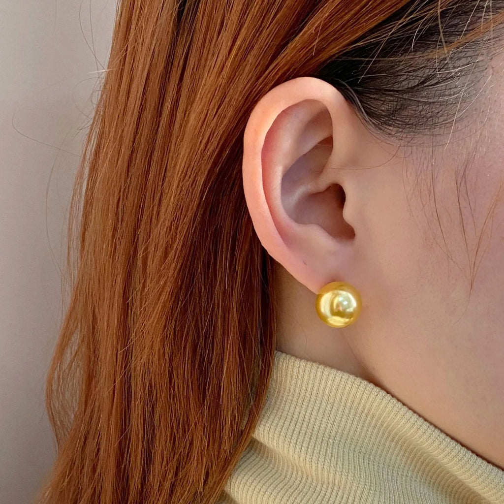Geometric large pearl stud earrings with an eight-point star detail on a silver setting.