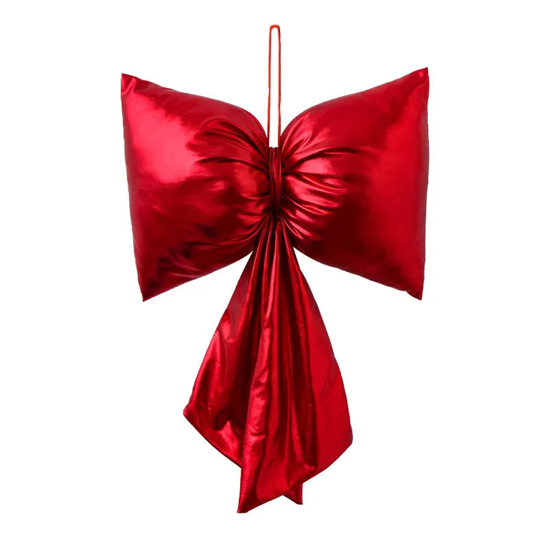 Christmas decorative bowknot with bright leather finish in red colour on a tree branch